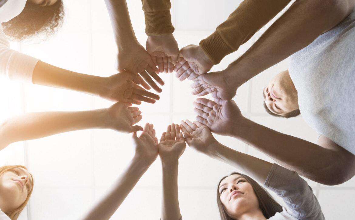 low-view-group-friends-holding-hands-together