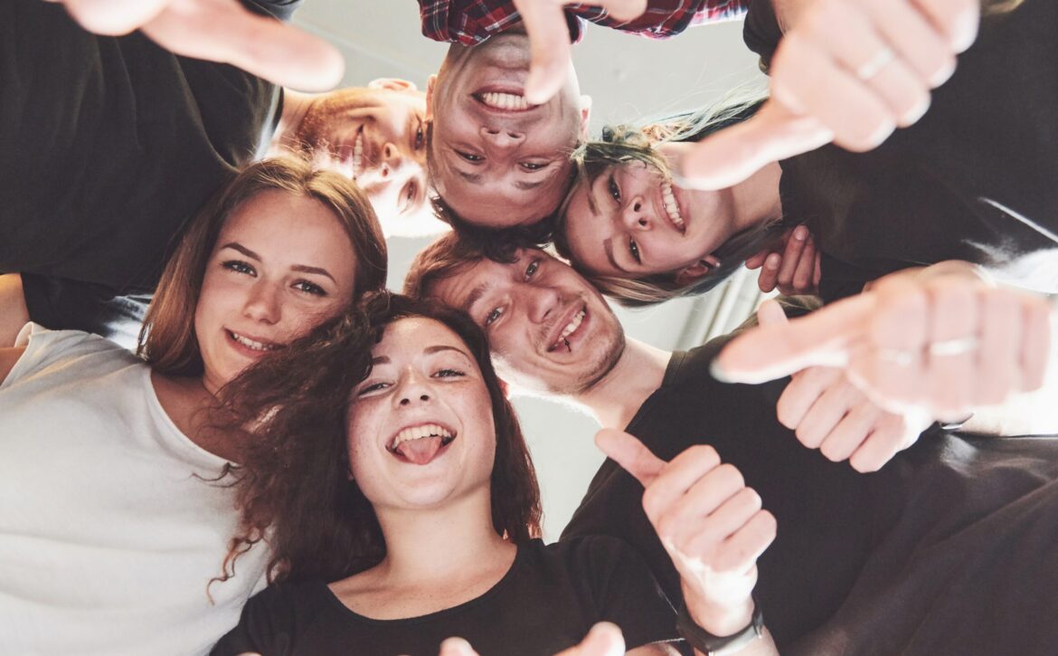 Happy group of friends with their hands together in the middle