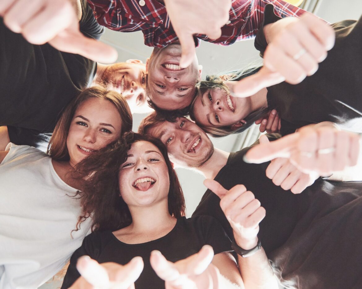 Happy group of friends with their hands together in the middle