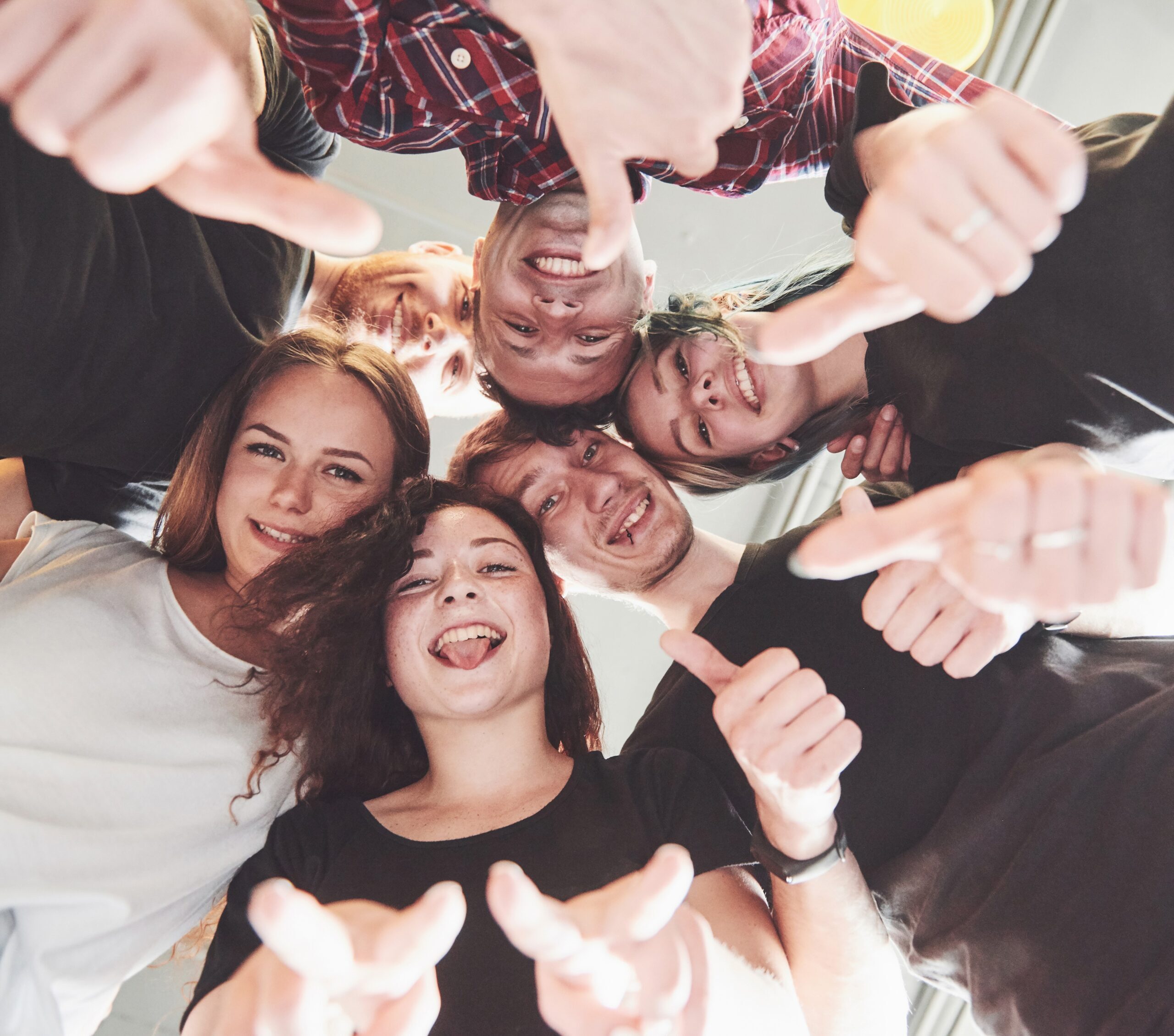 Happy group of friends with their hands together in the middle